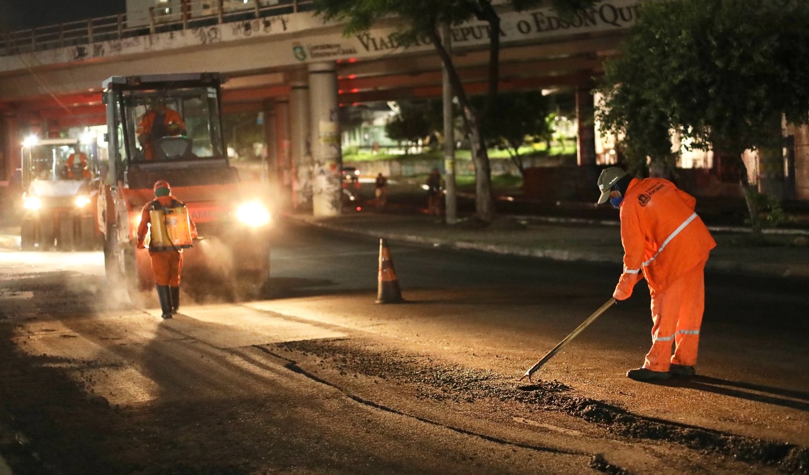 homens trabalhando no tapa-buraco da avenida josé bastos à noite